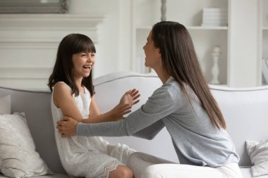 Küçük tatlı kızıyla oynayan neşeli bir anne.