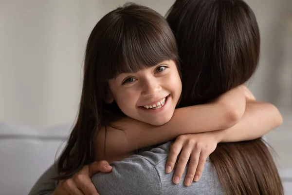 Sorrindo menina abraçando jovem mãe sentindo-se feliz — Fotografia de Stock