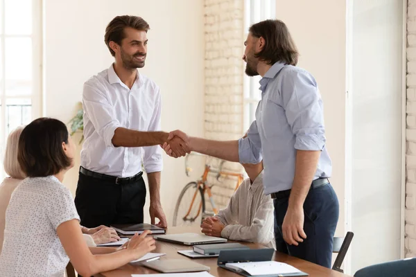 Sorrindo empresário aperto de mão colega masculino na reunião de equipe — Fotografia de Stock