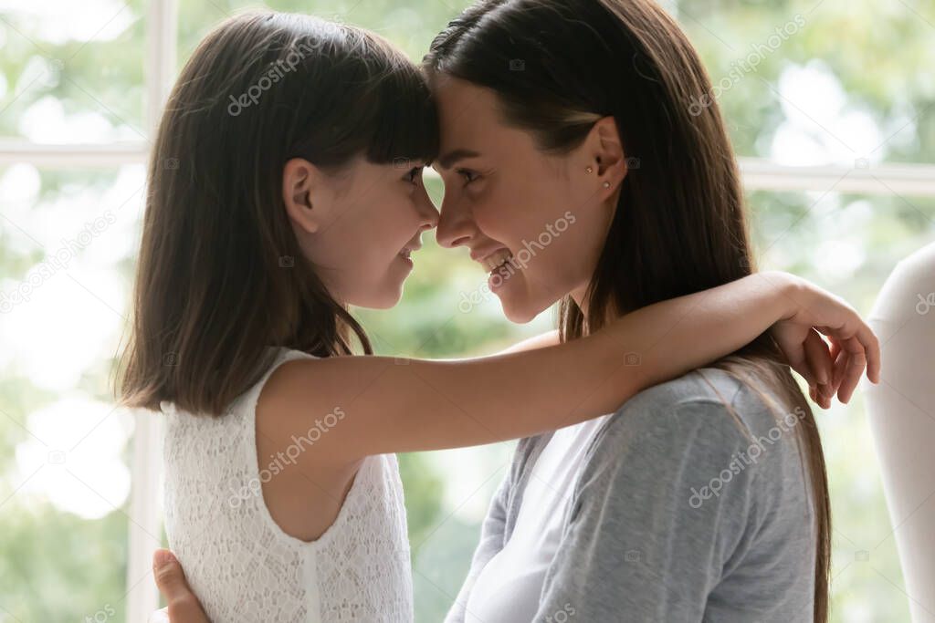 Happy young mom and little daughter having tender moment
