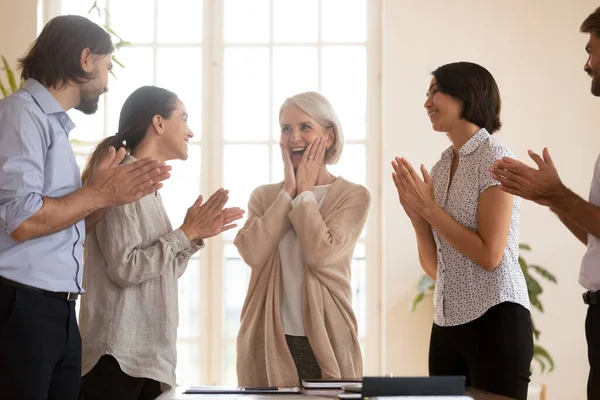 Szczęśliwi koledzy klaszczą w dłonie witając bizneswoman z sukcesem — Zdjęcie stockowe