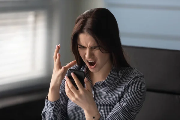 Akıllı telefonu tutan öfkeli kadın kızgın hissediyor. Bozuk alet tamir edilmesi gerekiyor. — Stok fotoğraf