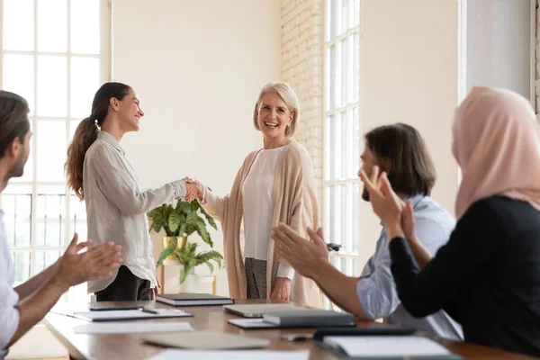 Smiling business woman handshake saludo empleado de mediana edad con empleo —  Fotos de Stock