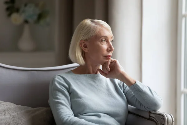 Pensativo mujer de mediana edad mirar en el pensamiento a distancia — Foto de Stock