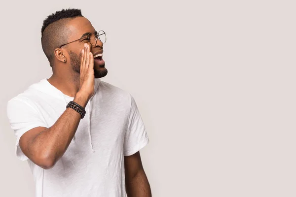 Excited black man scream at blank copy space in studio — Stock Photo, Image