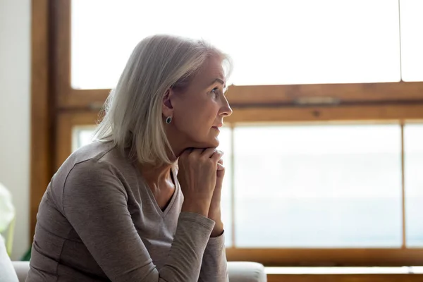 Upset mature woman look in distance feeling sad mourning — Stock Photo, Image