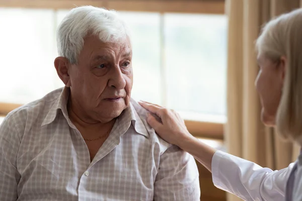 Aandachtige vrouwelijke arts tonen steun aan senior mannelijke patiënt — Stockfoto