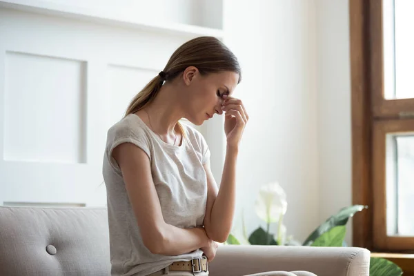 Fatigué jeune femme massage yeux souffrant de migraine — Photo