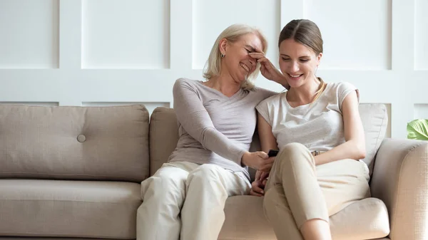 Sorridente anziano mamma e figlia guarda divertente video su cellulare — Foto Stock