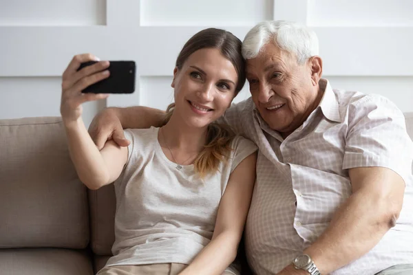 Szczęśliwy stary ojciec i dorosły córka zrobić selfie razem — Zdjęcie stockowe