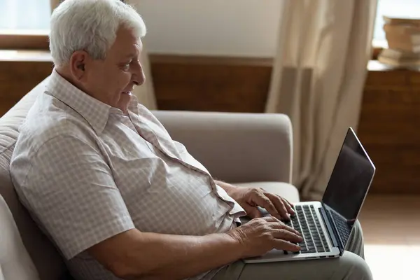 Senior man relax on couch using laptop — Stock Photo, Image