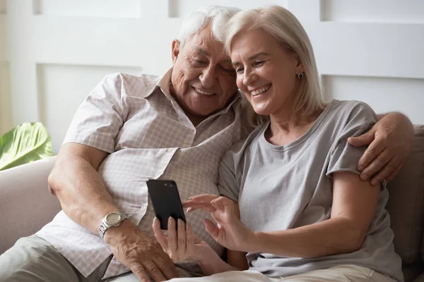 Mutlu yaşlı çift koltukta rahat rahat oturuyor.