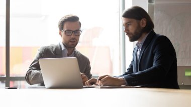 İş adamı gözlüklü danışman müşteri, dizüstü bilgisayarı gösteriyor.