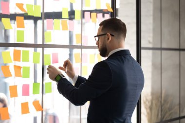 İşadamı, kurul odasını duvara yapışmış post-it müzakereleri için hazırlayın.