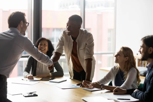 Diverse business partners shaking hands at meeting, making agreement — Stock Photo, Image