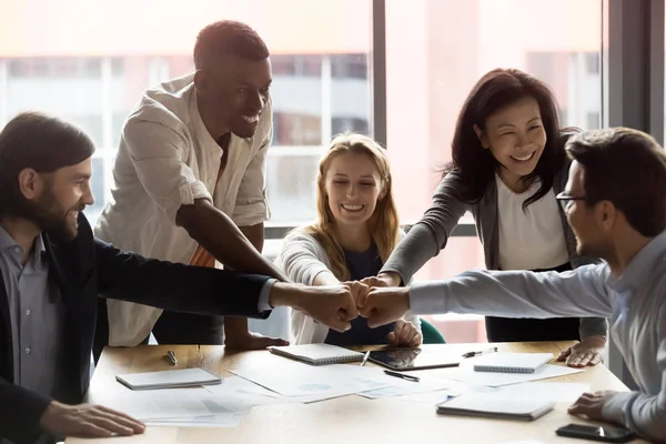 Happy diverse medewerkers team toetreden vuisten, het vieren van succes — Stockfoto