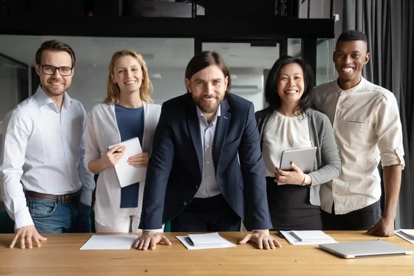 Sonriendo a diversas personas de negocios con líder de equipo mirando a la cámara — Foto de Stock