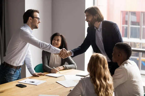 Smiling team leader shaking successful employee hand at corporate meeting — Stock Photo, Image