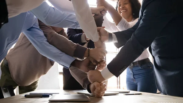 Multiracial happy affiliates stacked fists together involved in teambuilding activity — Stock Photo, Image