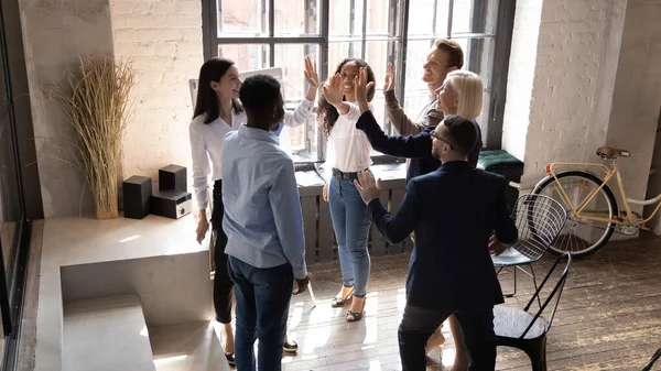 Diverse workers giving high five gesture of partnership and synergy