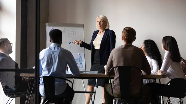 Aged trainer teaches diverse staff during corporate training at boardroom — Stock Photo, Image