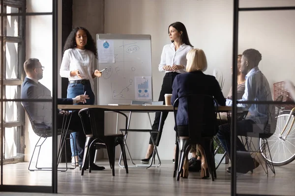 Diversas mujeres startupper haciendo presentación para inversionistas usando rotafolio — Foto de Stock