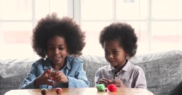 Two cute african children playing with playdough at home — Stockvideo