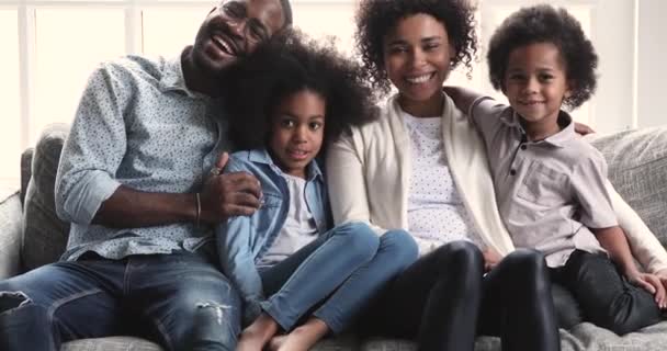 African parents posing for portrait sit with children on sofa — Stok video