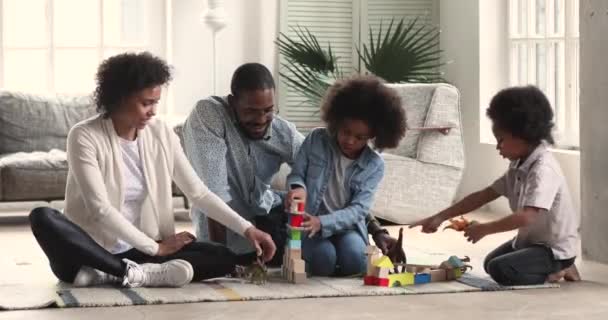 Afrikaanse ouders en twee kinderen die speelgoed spelen in de woonkamer — Stockvideo