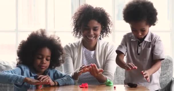 Africano mãe ensinar duas crianças bonitos jogando juntos esculpindo playdough — Vídeo de Stock