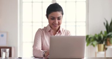 Excited indian businesswoman winner celebrating online win looking at laptop
