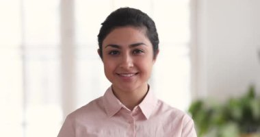 Closeup portrait of smiling millennial indian business woman in office