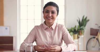 Happy indian business woman making video conference call in office