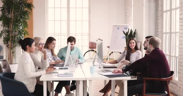 Multiethnic professional team use computers talk sit at meeting table — ストック動画