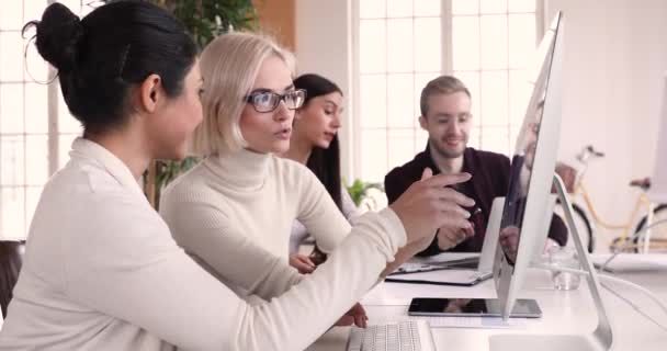 Diversas compañeras de trabajo discutiendo datos trabajando en computadora en la reunión — Vídeo de stock