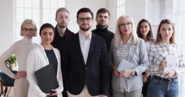 Confident smiling successful multicultural professional team looking at camera