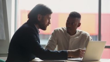 Manager explaining corporate software to young african american employee.