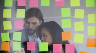 Male worker managing project tasks with middle aged korean supervisor.