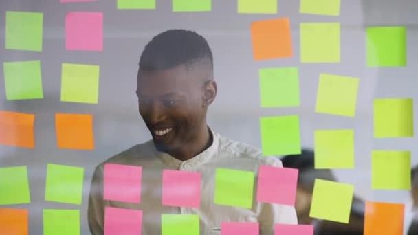 Lächelnder afrikanisch-amerikanischer junger erfolgreicher Manager mit Projektablauf zufrieden. — Stockvideo