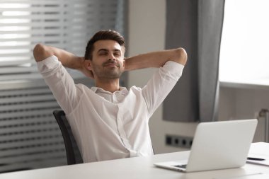 Mutlu erkek işçi işyerinde dinlenme sandalyesinde dinleniyor.