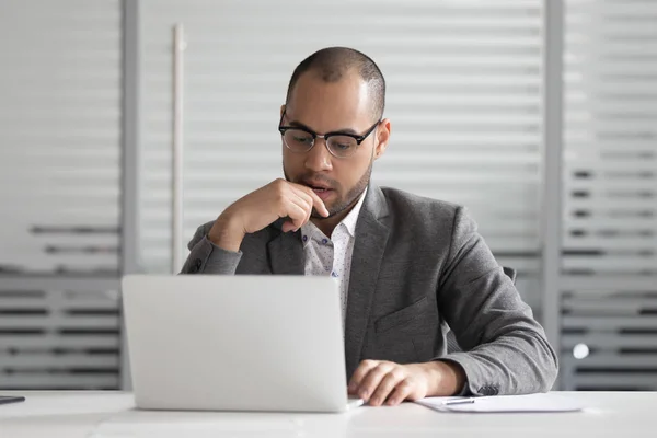 El empleado masculino pensativo mira el ordenador portátil piensa analizar problema — Foto de Stock