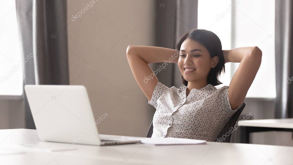 Smiling woman worker relax in chair at workplace