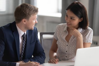 Çeşitli ofis çalışanları iş yerinde sohbet ediyorlar.