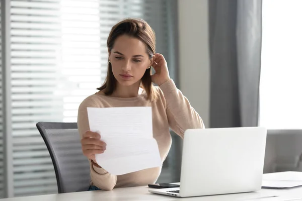 Сосредоточенная деловая женщина прочитала документ, работающий в офисе — стоковое фото