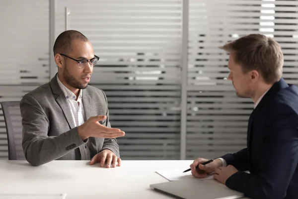 Solicitante masculino serio hablar con el empleador en la entrevista — Foto de Stock