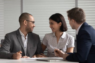 Happy couple talk making decision at realtor office