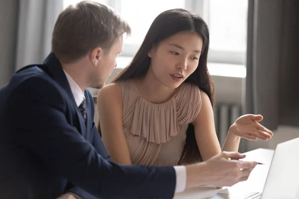 Multiethnic employees discuss project working on laptop in office — ストック写真