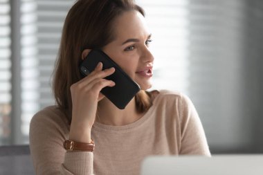 Close up of female employee talk on smartphone in office