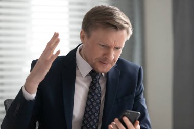 Mad male employee having smartphone problems or breakdown