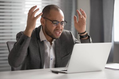 Mad male employee bothered by connection problems on laptop